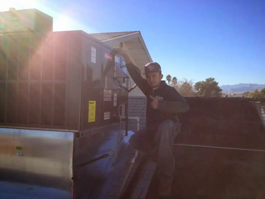 HVAC technician performing Air Duct Repair on a rooftop unit in Providence